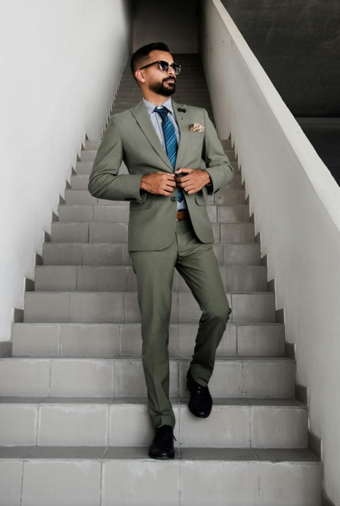 A fashionable man in a suit walking up stairs in Dubai, projecting confidence and style.